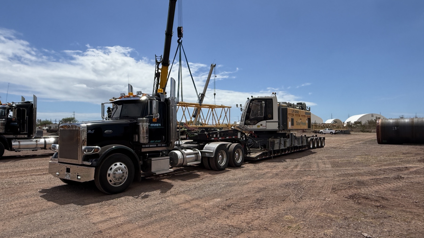 Stone's lowboy hauling a crane component through an industrial yard