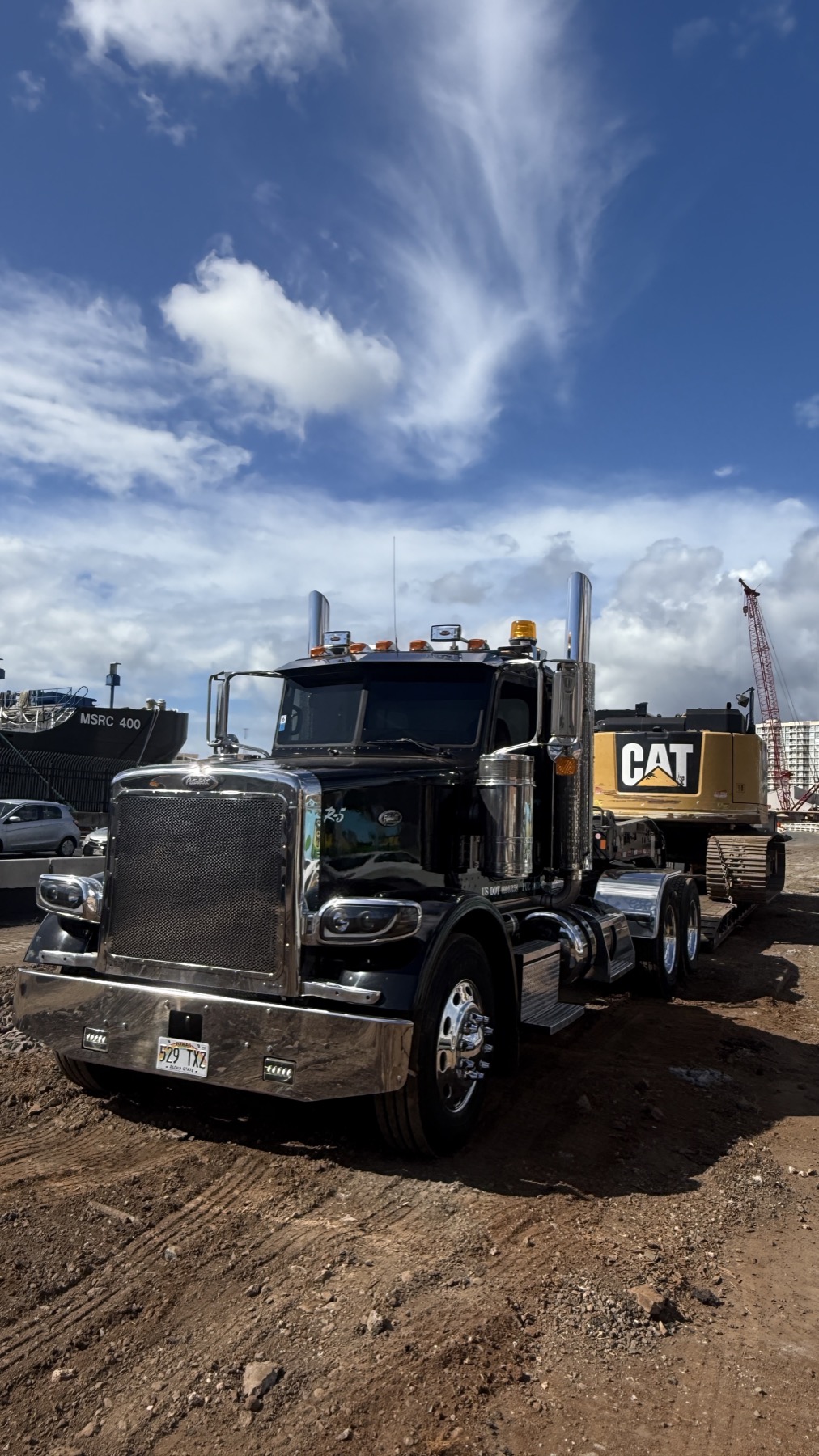 Stone's truck hauling a CAT excavator near Honolulu harbor