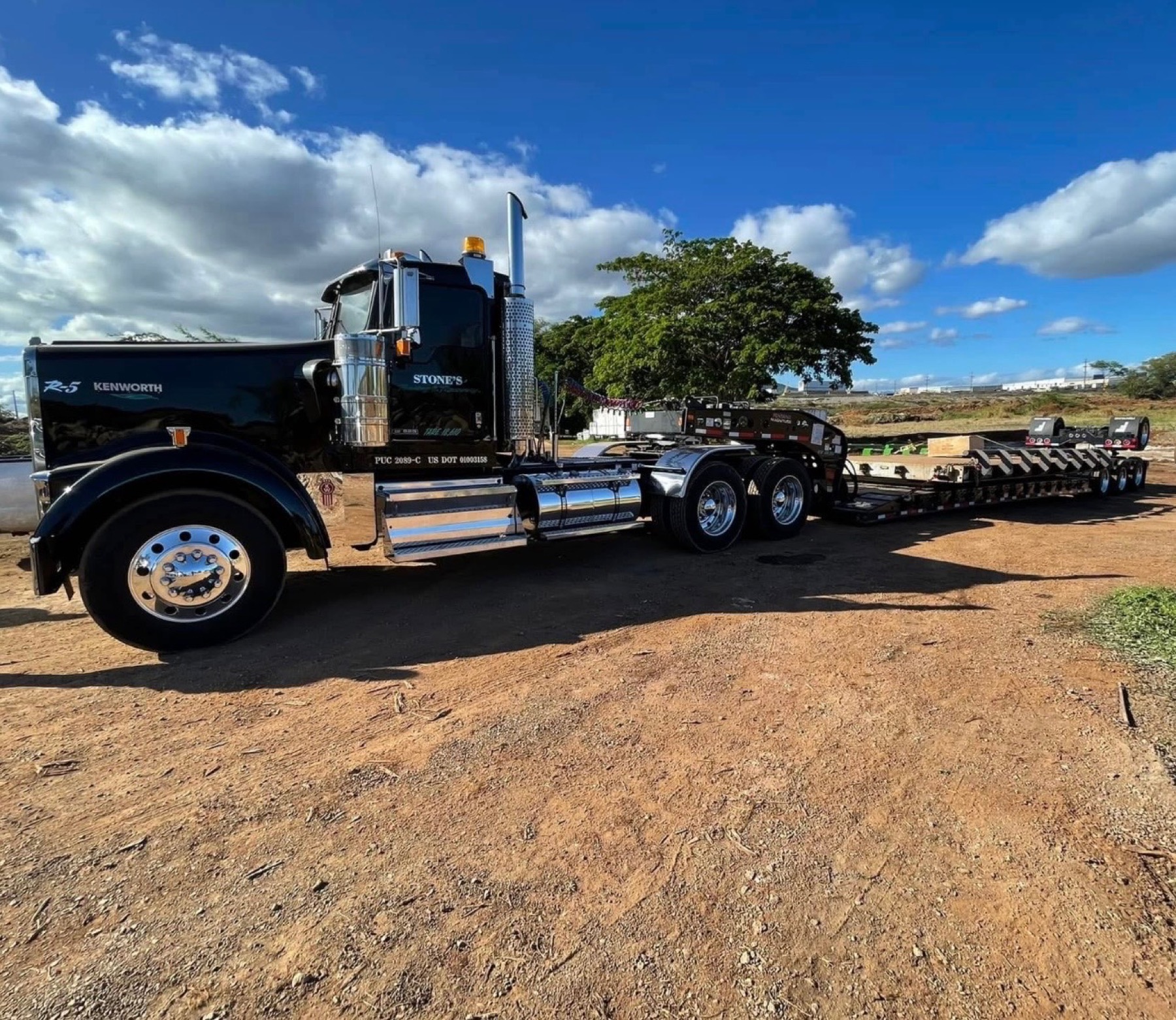 Stone's Kenworth truck and lowboy trailer under open Oahu skies