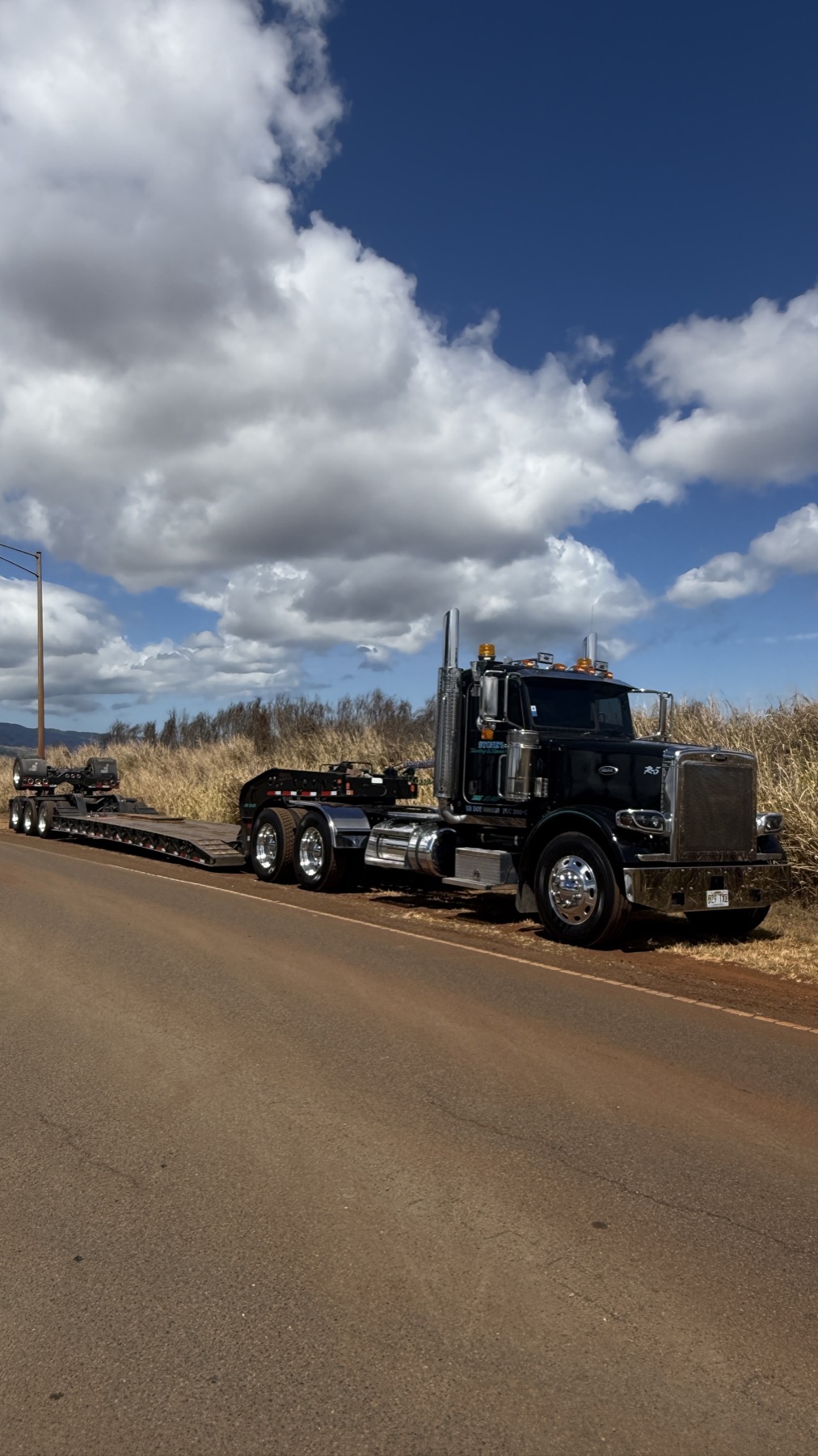 Stone's lowboy trailer parked along a rural Oahu road