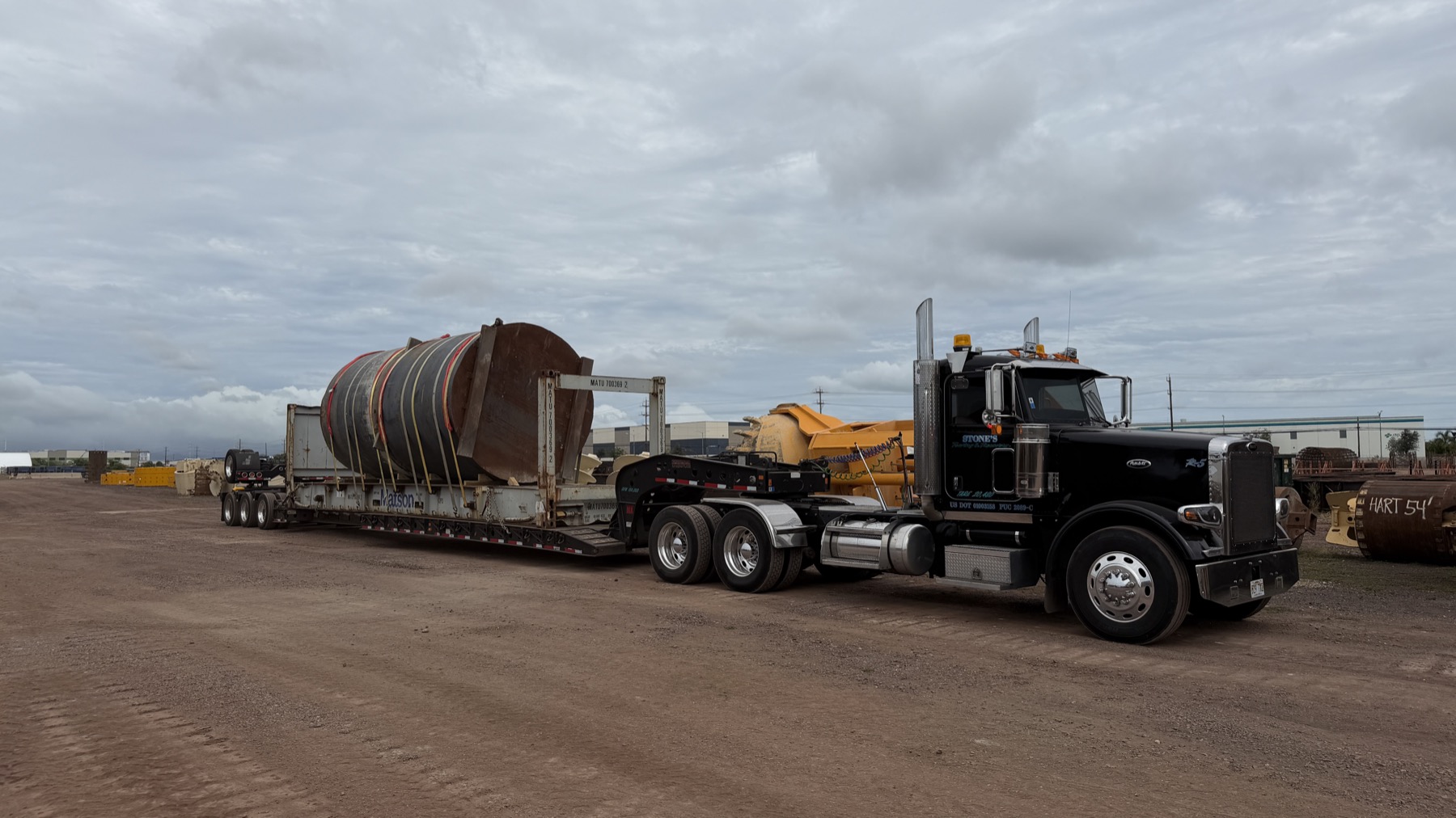 Stone's lowboy trailer hauling heavy industrial cargo across Oahu
