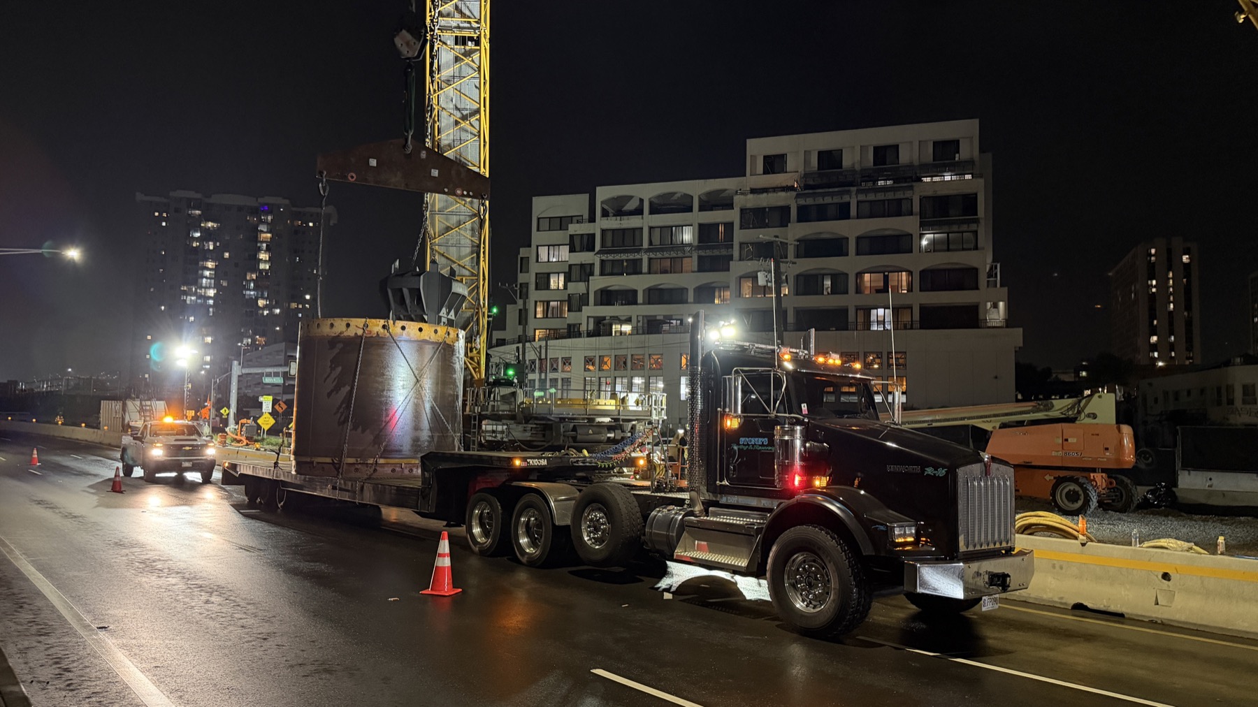 Stone's truck hauling a large steel component at night